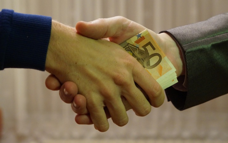 Datore di lavoro che passa dei soldi al dipendente durante una stretta di mano