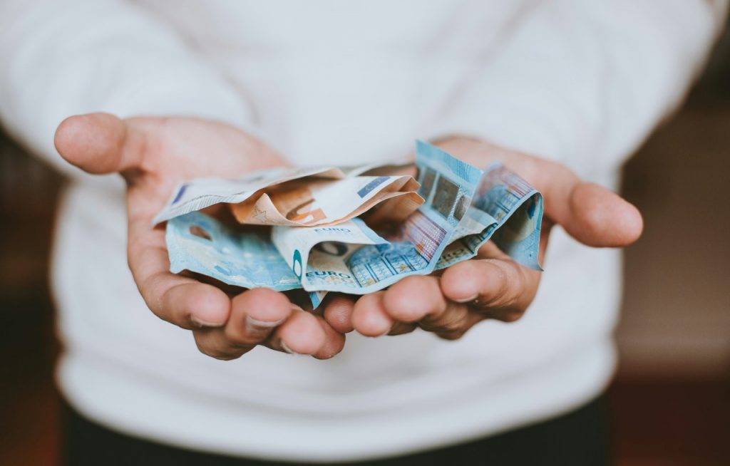 Uomo che mostra delle banconote euro