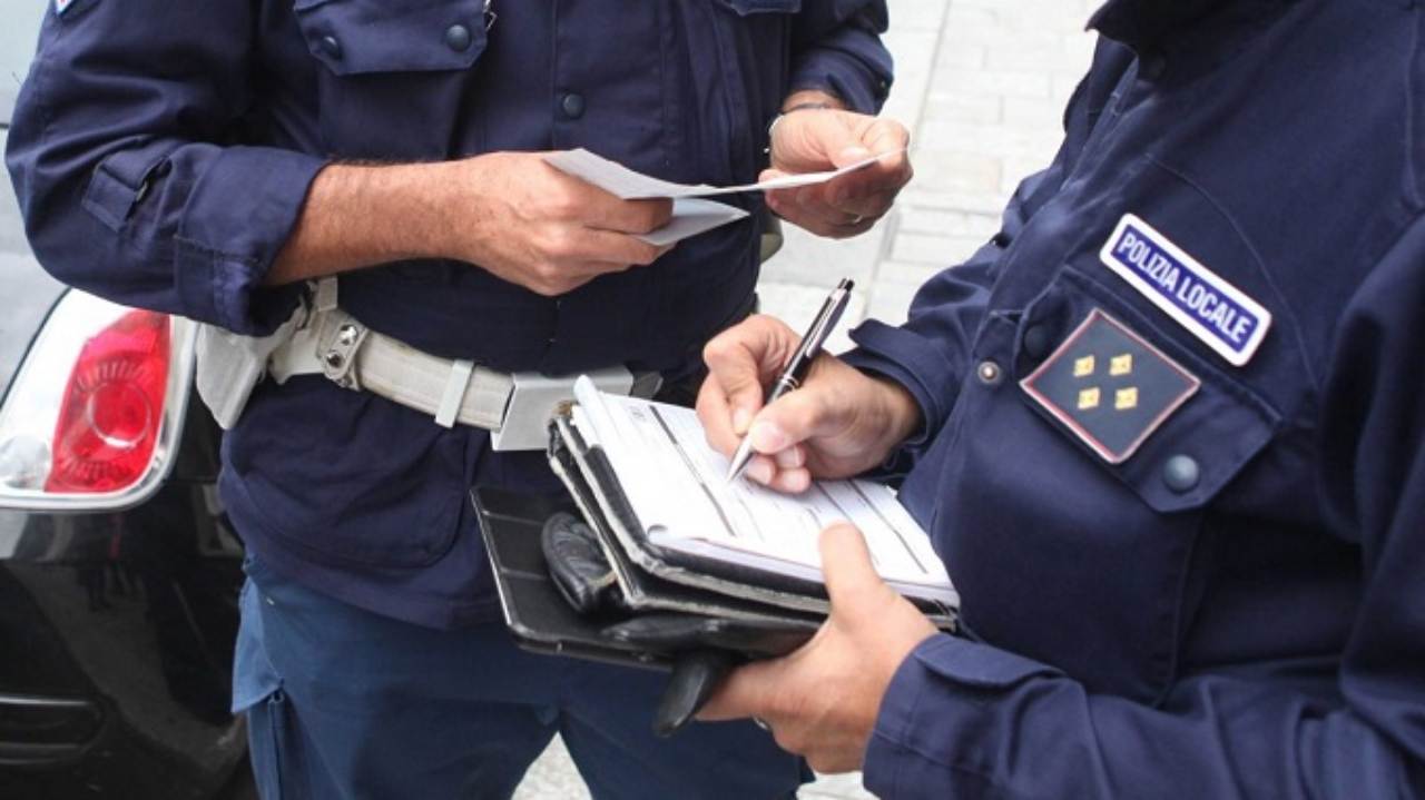 Due agenti della Polizia municipale che fanno una multa
