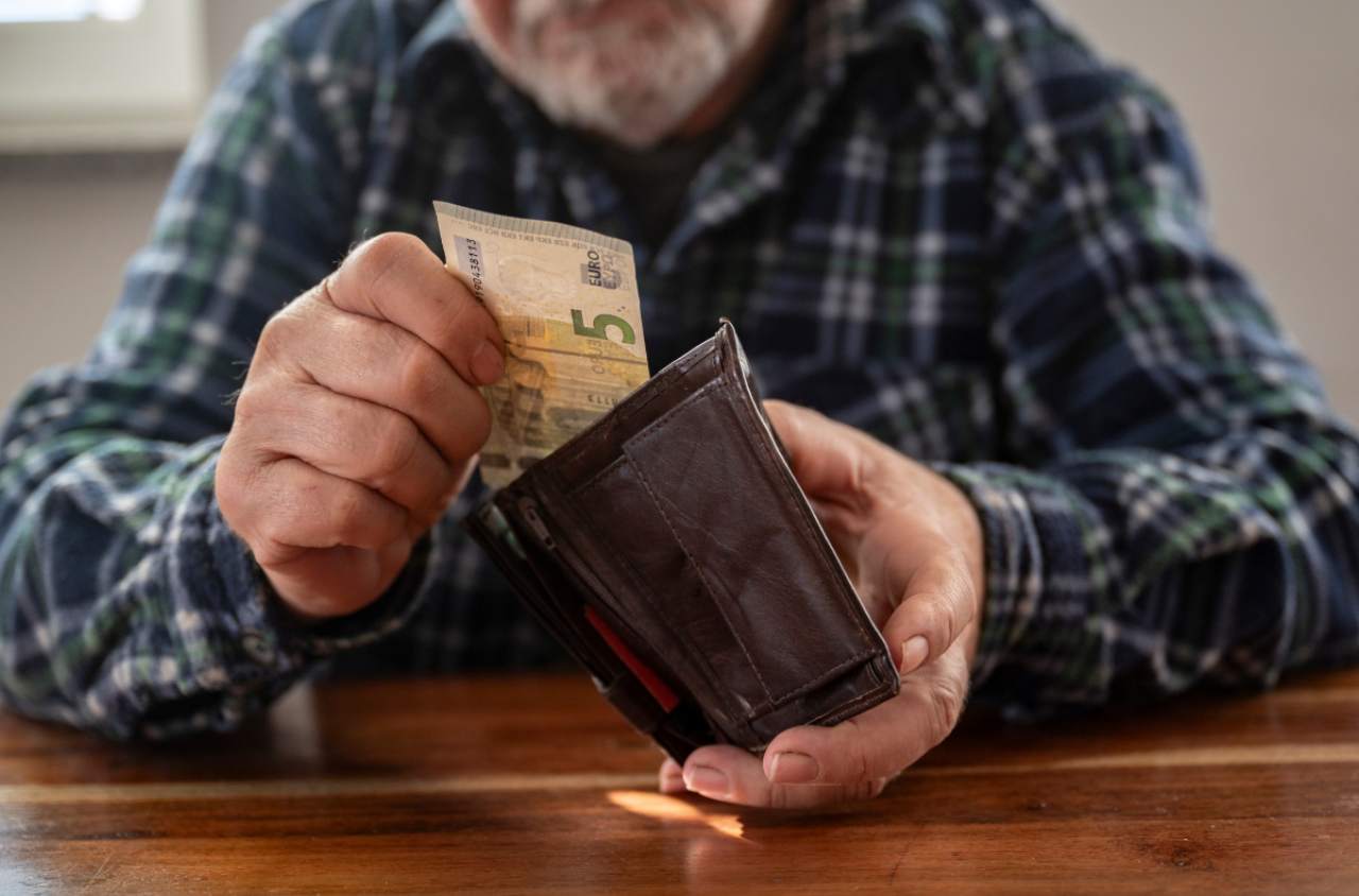 Pensionato che tira fuori 5€ dal portafoglio